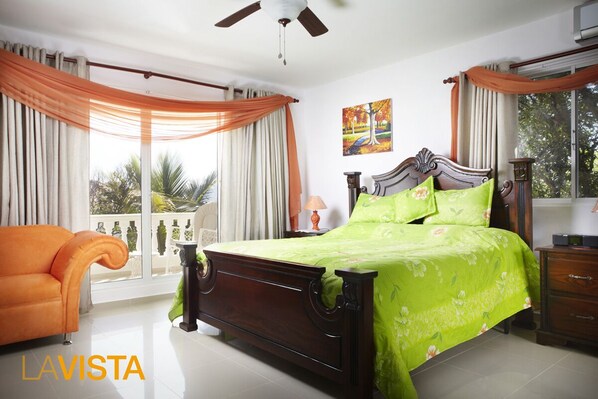 A bedroom with a bed, a chair, a nightstand, and a window with curtains.