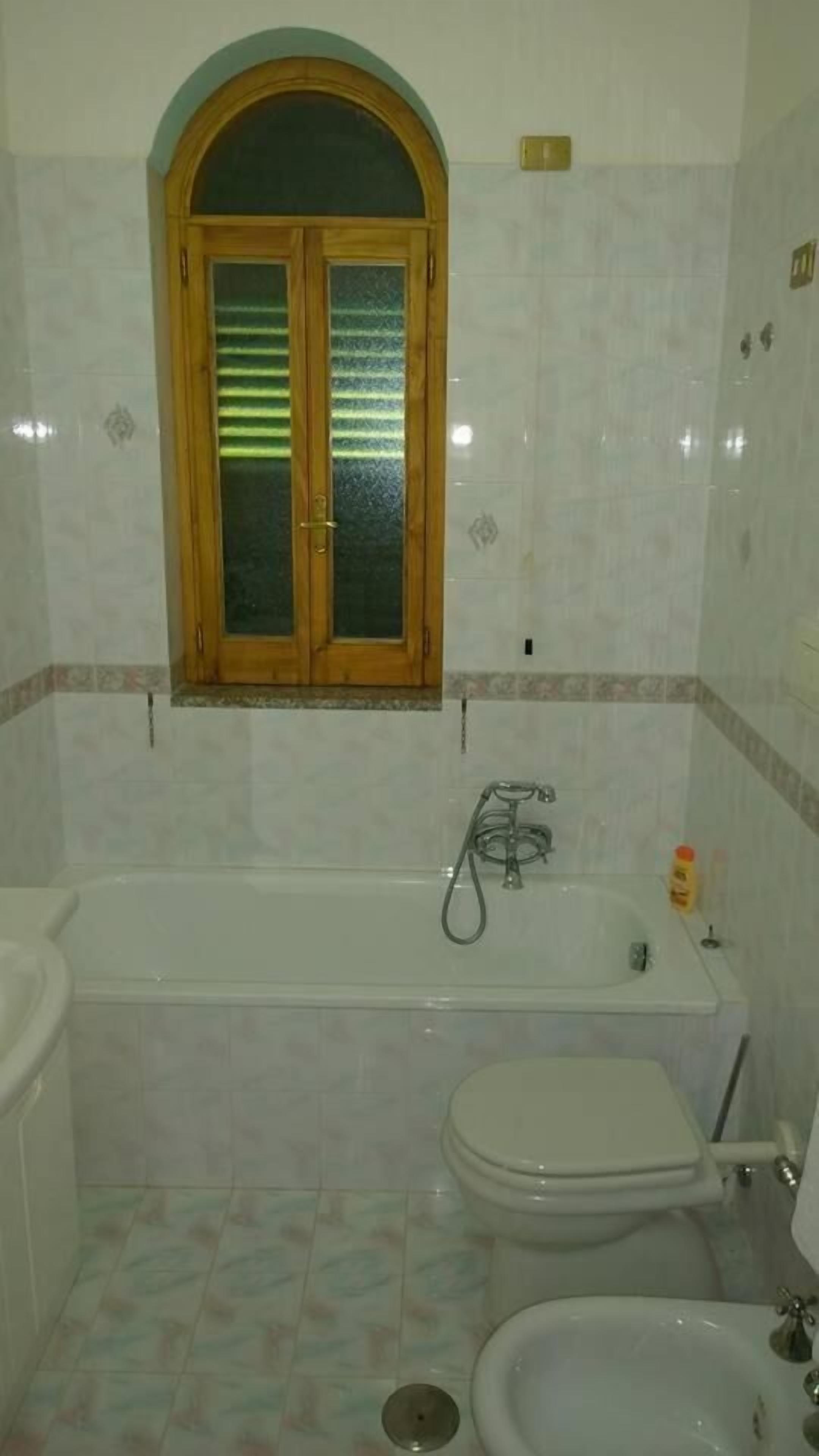 A bathroom with a bathtub, toilet, and bidet.