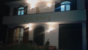Villa Bianca, un bâtiment à deux étages doté de fenêtres en arc de cercle et d’une porte de garage.