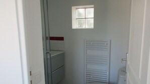 A small bathroom with a window, a towel rack, and a toilet. - 2 minutes walk from the beach (Pornic)