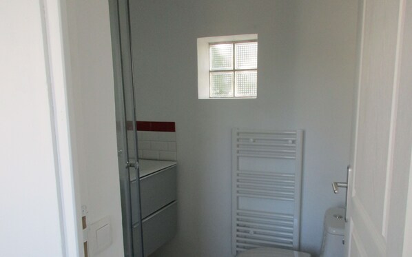 A small bathroom with a window, a towel rack, and a toilet. - 2 minutes walk from the beach (Pornic)