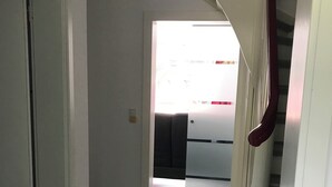 Un couloir avec un escalier menant à une pièce.