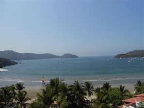 Enjoy a serene beachside retreat with breathtaking views of the ocean and surrounding hills.