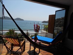 Relax on the balcony with a hammock chair and lounge chair, taking in the breathtaking views of the sea, boats, and distant landmass.