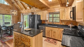 Eine Holzhütte mit Küche und Essbereich, Granit Arbeitsplatten und einem schwarzen Herd.