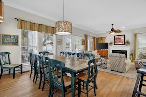 A dining area with a wooden table and chairs, a fireplace, and a television.