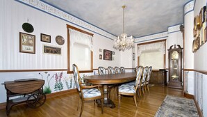 A dining room with a wooden table and chairs, a chandelier, and a vintage clock. - Breckenridge Vacation Home For Rent within walking distance to all amenities (Breckenridge)