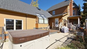 A house with a patio area, a hot tub, and a covered outdoor seating area. - Breckenridge Vacation Home For Rent within walking distance to all amenities (Breckenridge)