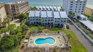 Un hotel con piscina, varios balcones y vista al océano.
