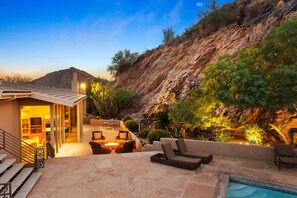 A modern outdoor living area with a pool, seating, and a view of a rocky hillside. - Exquisite Mountainside Estate Overlooking Pv Golf Course (Paradise Valley)