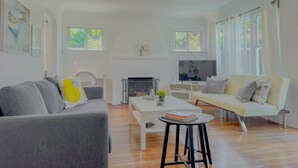 Ein modernes Wohnzimmer mit Kamin, einer Couch, einem Couchtisch und einem Fernseher.