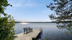 A wooden dock with two benches and a ladder leading into a calm lake. - Kärkiniemi (Tuusniemi)
