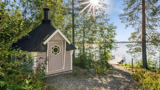 A small cabin with a chimney, surrounded by trees and a lake view. - Kärkiniemi (Tuusniemi)
