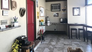 A kitchen with a red door, a ceiling fan, and various kitchen appliances. - Country West Motel (Rock Springs)