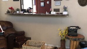 A room with a mirror, hats, a typewriter, and a wicker basket. - Country West Motel (Rock Springs)