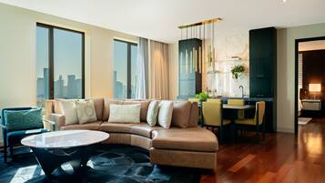 A modern living room with a curved sofa, a round coffee table, and a dining area with chairs.