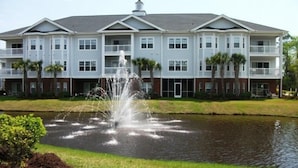 A multi-story hotel with a central courtyard featuring a fountain.