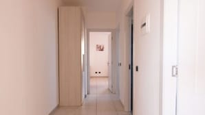 A narrow hallway with a door on the right and a door at the end. - Residence Le Groane (Garbagnate Milanese)