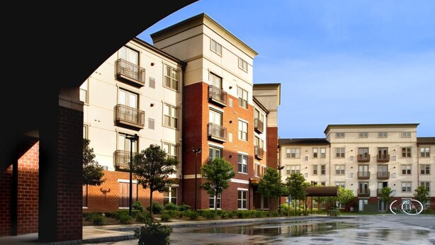 A multi-story residential building with a brick facade, multiple balconies, and a courtyard with a fountain. - Bluebird Suites in Downtown Providence (Providence)