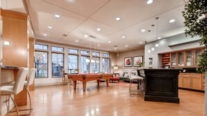 A spacious room with a pool table, a bar area, and large windows offering a city view. - Bluebird Suites in Downtown Providence (Providence)