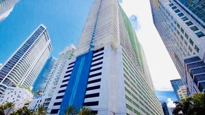 A high-rise building with a prominent blue vertical stripe, surrounded by other tall buildings. - Stay at Brickell by Executive Corporate Rental (Miami)