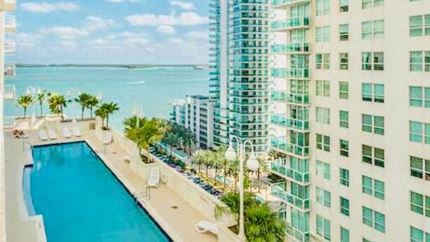 A high-rise hotel with a pool, overlooking a body of water. - Stay at Brickell by Executive Corporate Rental (Miami)