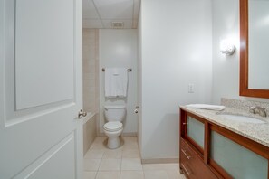 A bathroom with a toilet, a sink, and a mirror.