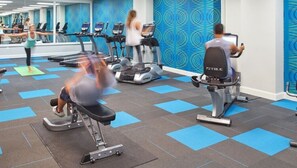 A gym with treadmills, elliptical machines, and weight benches.