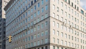 Ein großes, mehrstöckiges Hotel mit einer symmetrischen Fassade, zahlreichen Fenstern und einem zentralen Eingang mit Rundbögen.