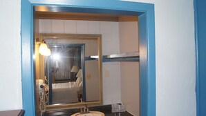 Un baño con un espejo grande, un lavabo y un perchero para toallas.