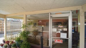 Un escaparate con puerta de cristal, un letrero que dice 'No vendedores ambulantes', uno que indica 'No fumar' y uno con la inscripción 'Ventanilla Nocturna'.