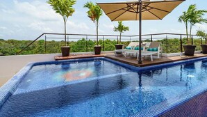 A rooftop pool with a clear view of the surrounding landscape, a lounge area with chairs, and a large umbrella providing shade. - Ka Suites Tulum by HA (Tulum)