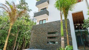 A modern two-story building with a stone facade, large windows, and a balcony. - Ka Suites Tulum by HA (Tulum)