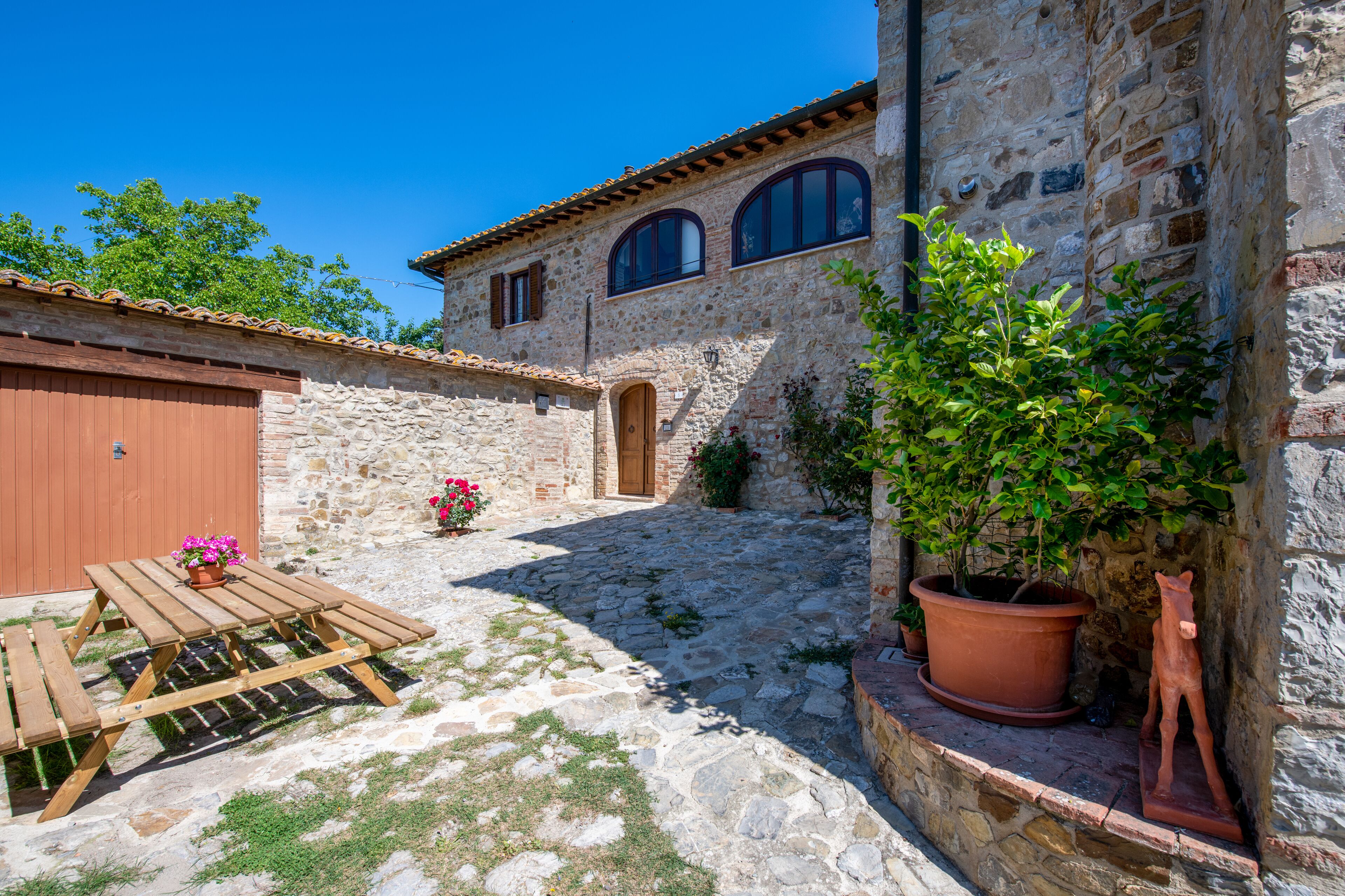 A stone building with a wooden table and potted plants.