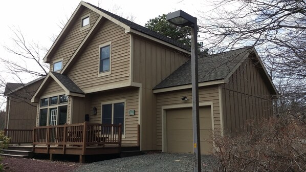 A two-story house with a front porch, a garage, and a small deck. - Beautiful home, hot tub, across from Camelback Resort (Tannersville)