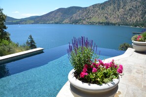 A clear view of a swimming pool with a mountain backdrop and a flower planter in the foreground.