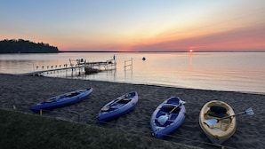 A beach with kayaks and a dock. - Huge Private Sandy Beach! Sleeps 22! Private Suites! Some Aug/Sept Availability! (Onaway)