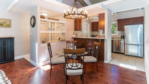 Una cocina moderna con una isla central, armarios de madera y electrodomésticos de acero inoxidable.
