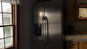 A compact kitchen with a refrigerator, wooden cabinets, a window, and a sink. - "Tranquility Base" is a place where you can lose yourself in nature. (St George)