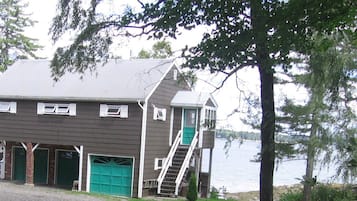 A two-story building with a private entrance to an attached apartment, featuring a green door and a stairway.
