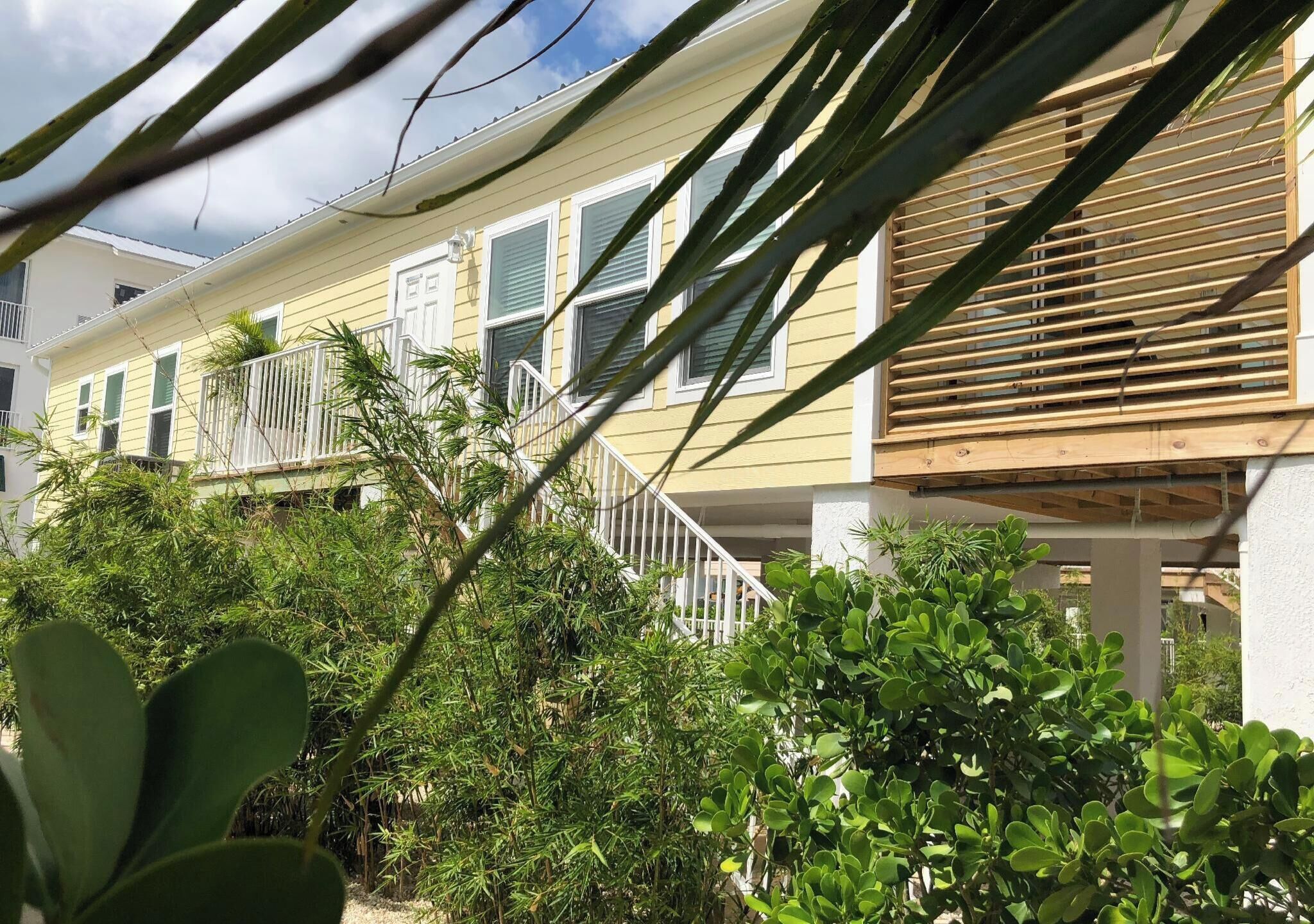 A row of yellow houses with balconies and wooden decks.