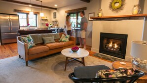 Una sala de estar acogedora con chimenea, un sofá y una mesa de centro.