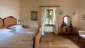 A hotel room with a large bed, a dresser, a mirror, and a window with curtains.
