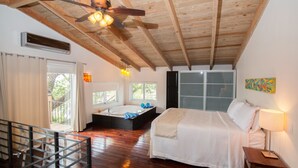 Quarto com cama grande, banheira e varanda com vista.