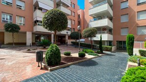 Un patio con un sendero empedrado, rodeado de edificios de varios pisos con balcones.