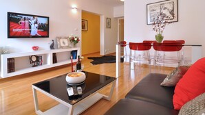 A modern living room with a TV, sofa, coffee table, and red chairs. - Beachfront Apartment Barbara, near Bacvice beach walking distance from old town  (Split)