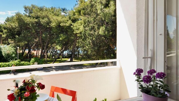 A balcony with a table set for dining, a chair, and a potted plant. - Beachfront Apartment Barbara, near Bacvice beach walking distance from old town  (Split)