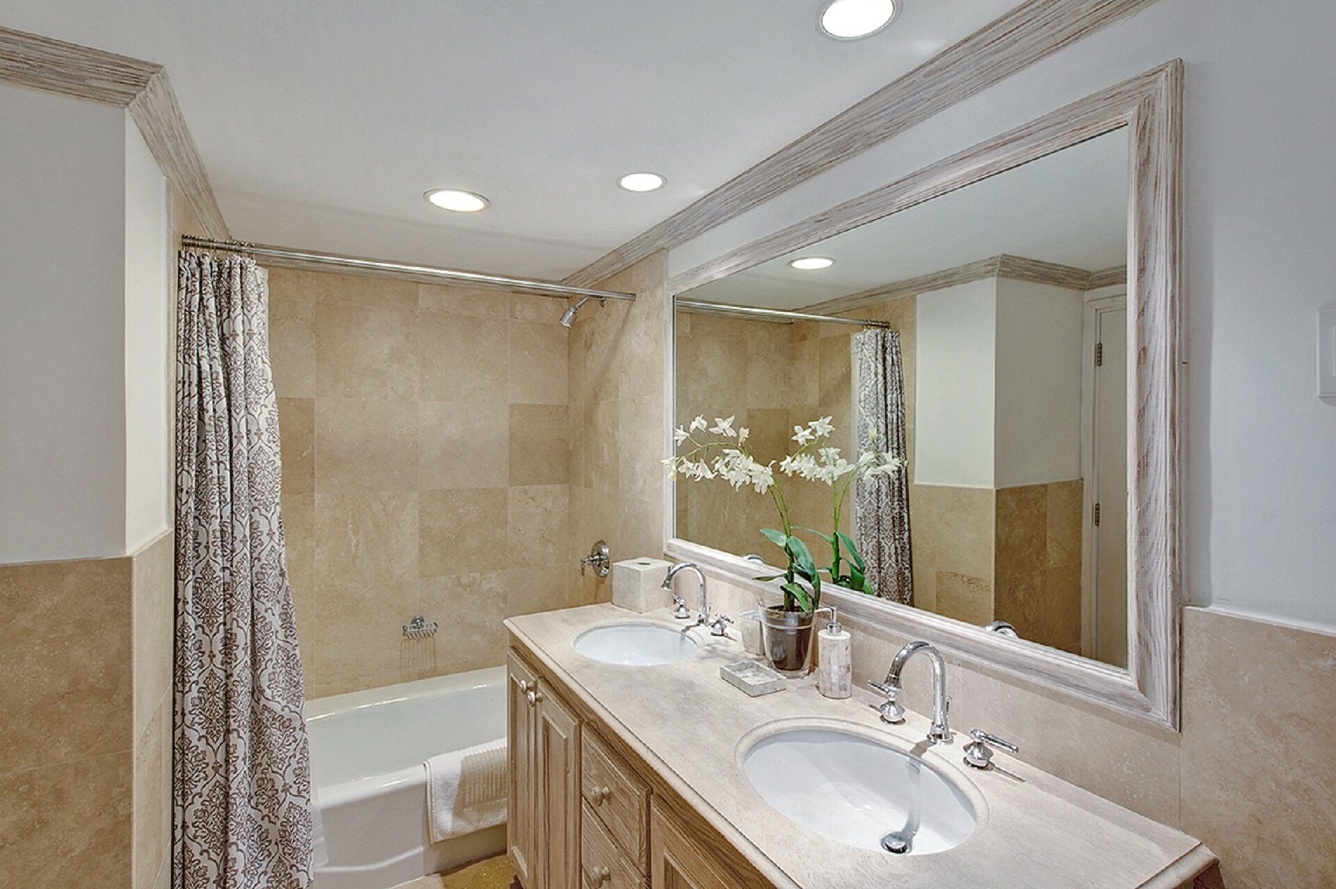 Une salle de bain avec deux lavabos, une baignoire, une douche et un grand miroir.