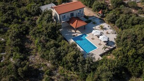 An aerial view of a house with a swimming pool, surrounded by dense greenery. - Luxury villa with heated pool, Marina-Trogir (Pozorac, Marina)