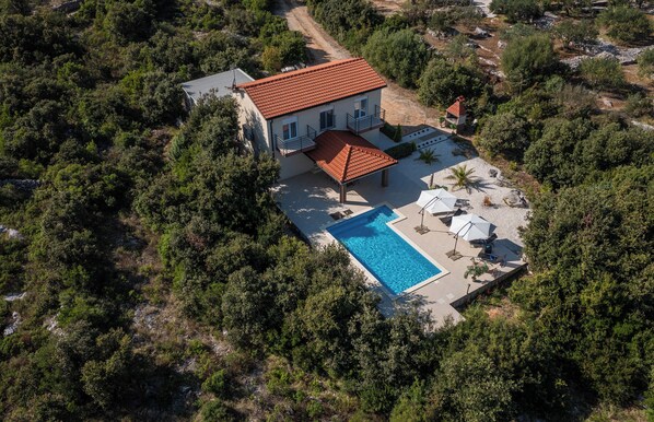 An aerial view of a house with a swimming pool, surrounded by dense greenery. - Luxury villa with heated pool, Marina-Trogir (Pozorac, Marina)